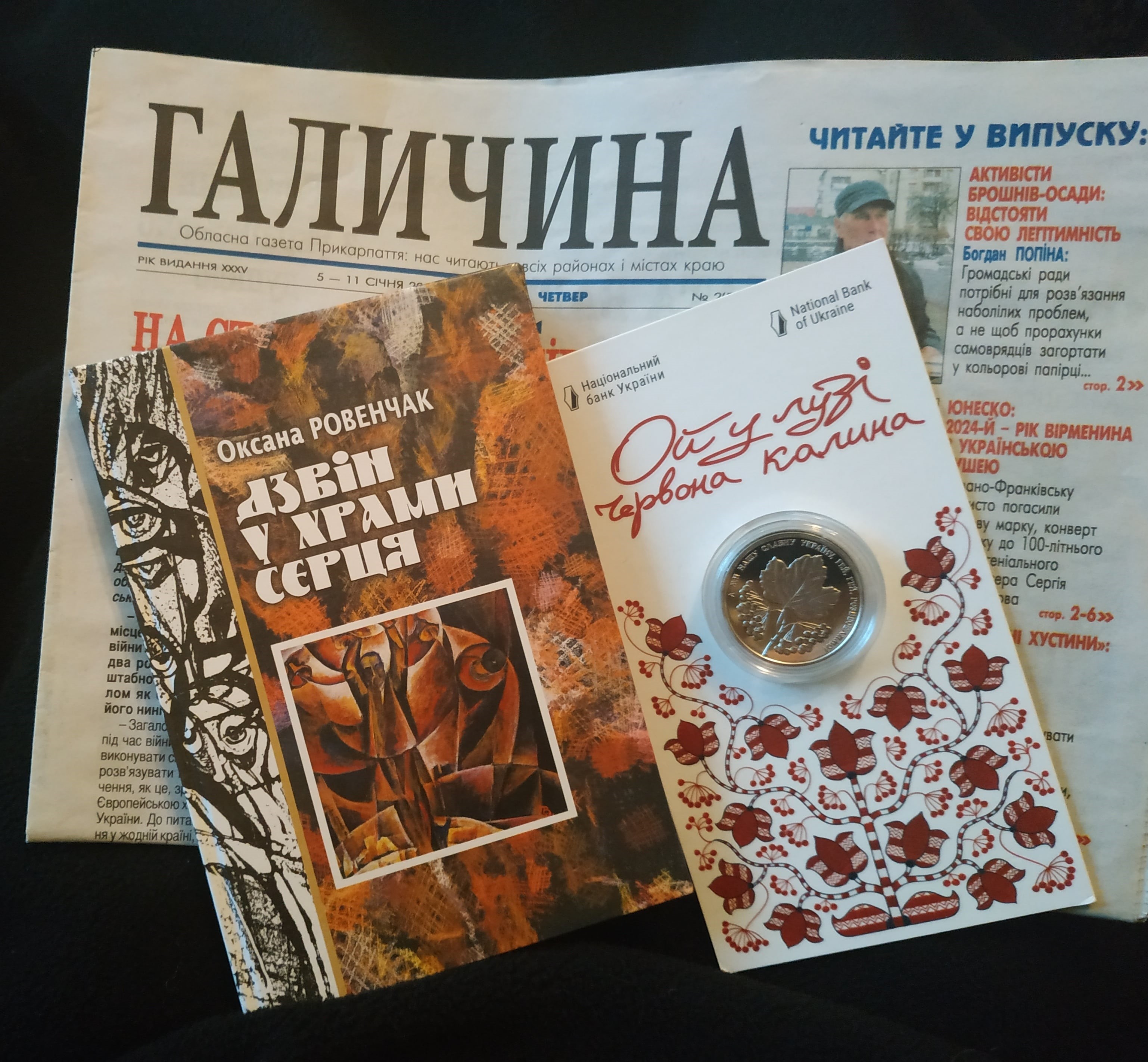 Пам’ятні подарунки для американської мами героїчного Ітана Гертвека – Леслі Гертвек та Українському національному музею в Чикаго: газета «Галичина» з розповіддю про полеглого Ітана Гертвека, знакова монета НБУ «Ой у лузі червона калина» та книжка есеїв «Дзвін у храми серця». (Світлина авторки).