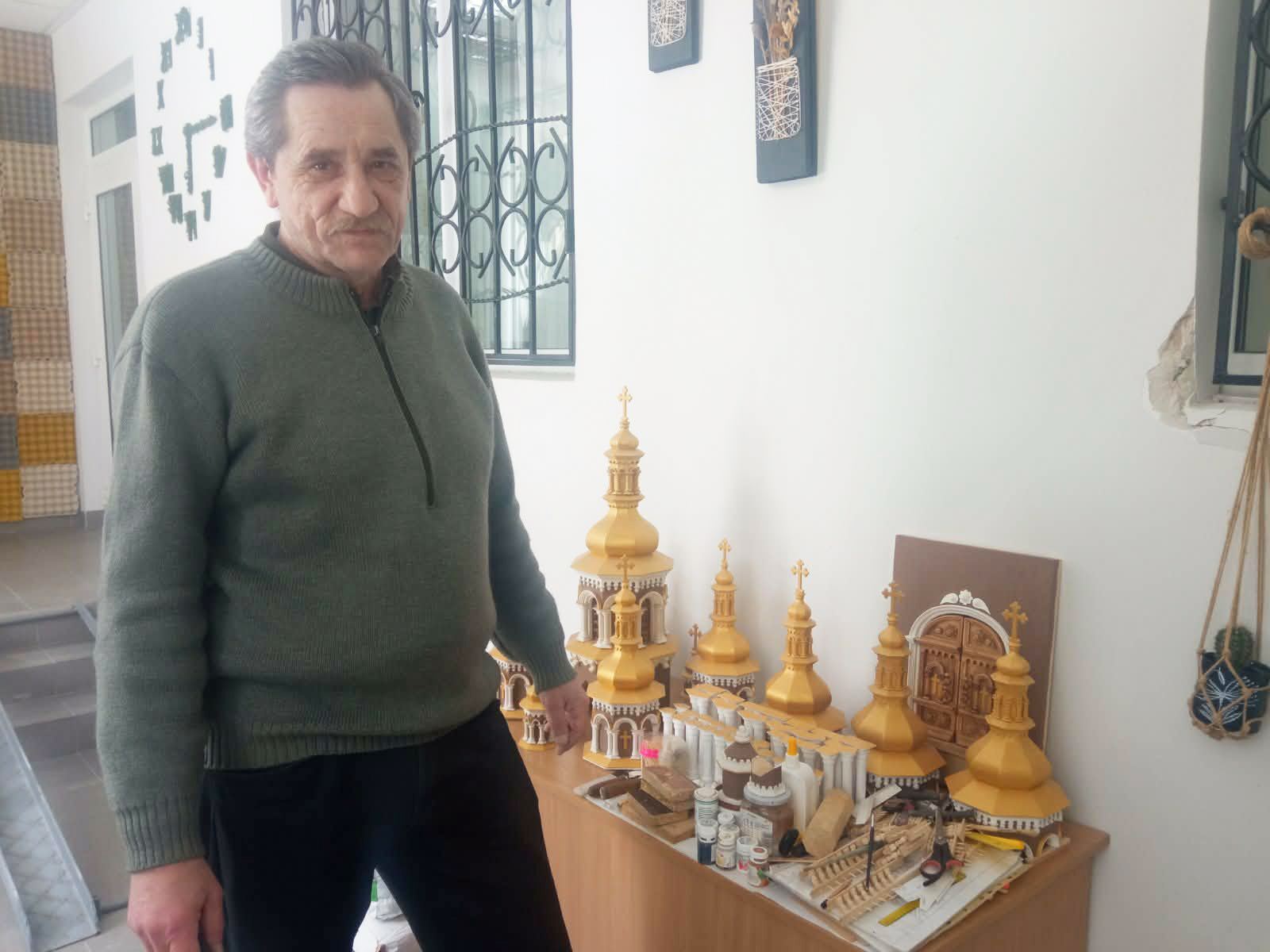 Любомир Чорномаз біля столика з деталями майбутньої церкви. 