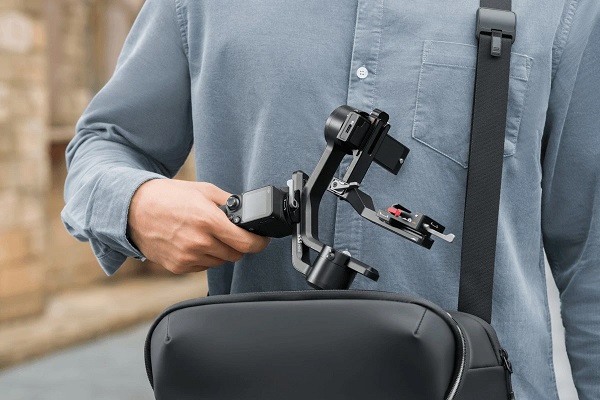 Компактний стабілізатор DJI RS 3 Mini у складеному стані дістають із міської наплечної сумки
