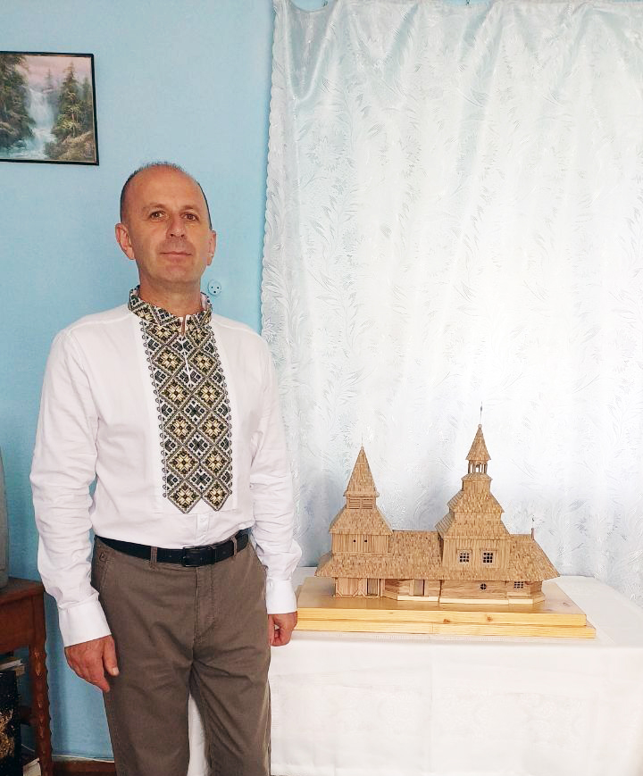 Майстер Олег Волощук біля новоствореної мінікопії церкви Святого Духа у Рогатині.