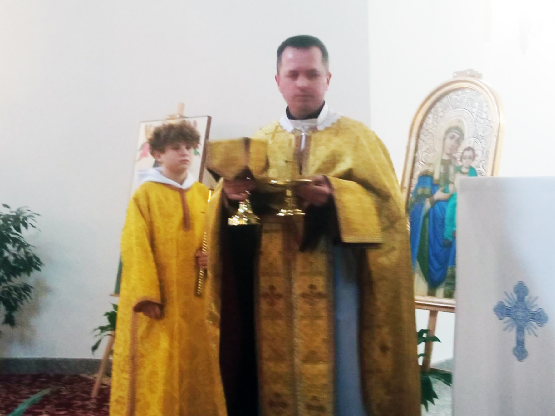 Отець Василь Слобода та його юний помічник Данило під час таїнства Святого Причастя у дрогобицькому василіянському храмі Святих Петра і Павла УГКЦ.